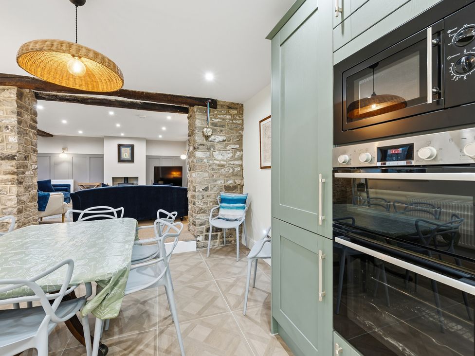 A kitchen with a table and chairs and appliances at The Forge in Castleton, Peak District