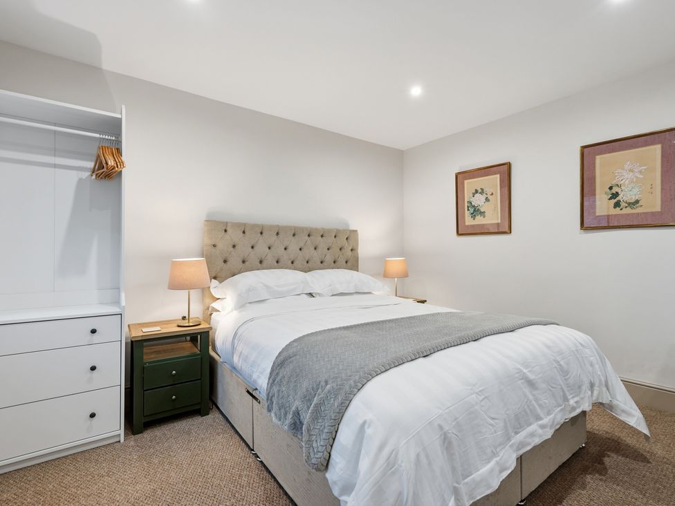 A bedroom with a bed, lamp, and wardrobe at The Forge in Castleton, Peak District