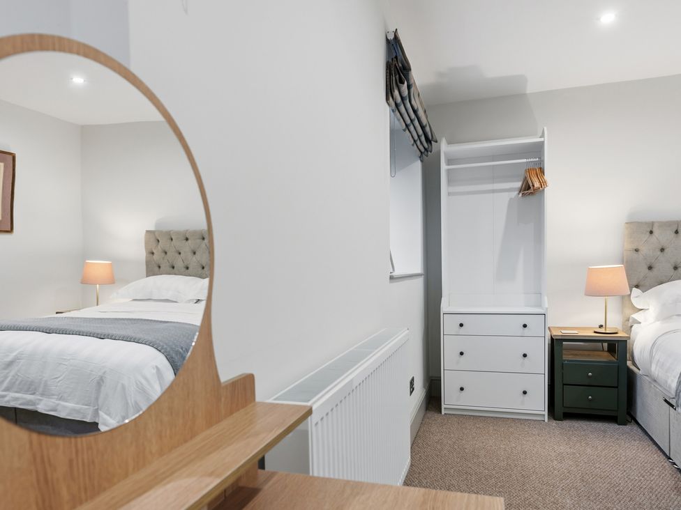 A bedroom with beds and storage at The Forge in Castleton, Peak District