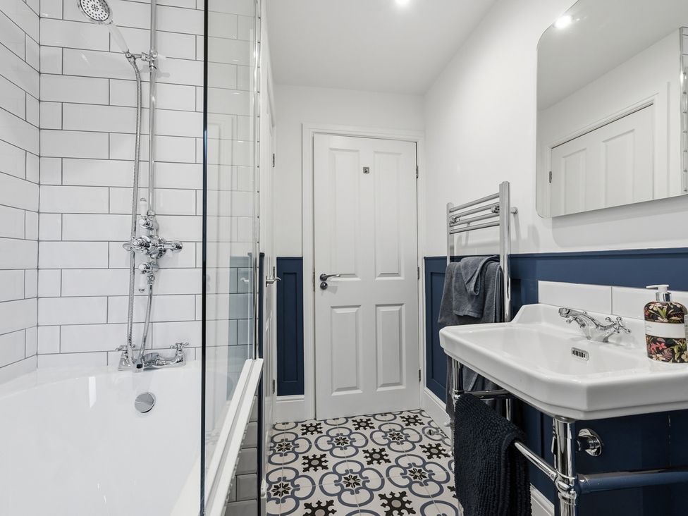 A bathroom with shower, bathtub, sink, and towel rail at The Forge in Castleton, Peak District