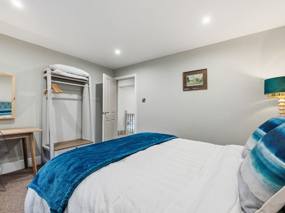 A bedroom with a bed and clothes rack at The Forge in Castleton, Peak District