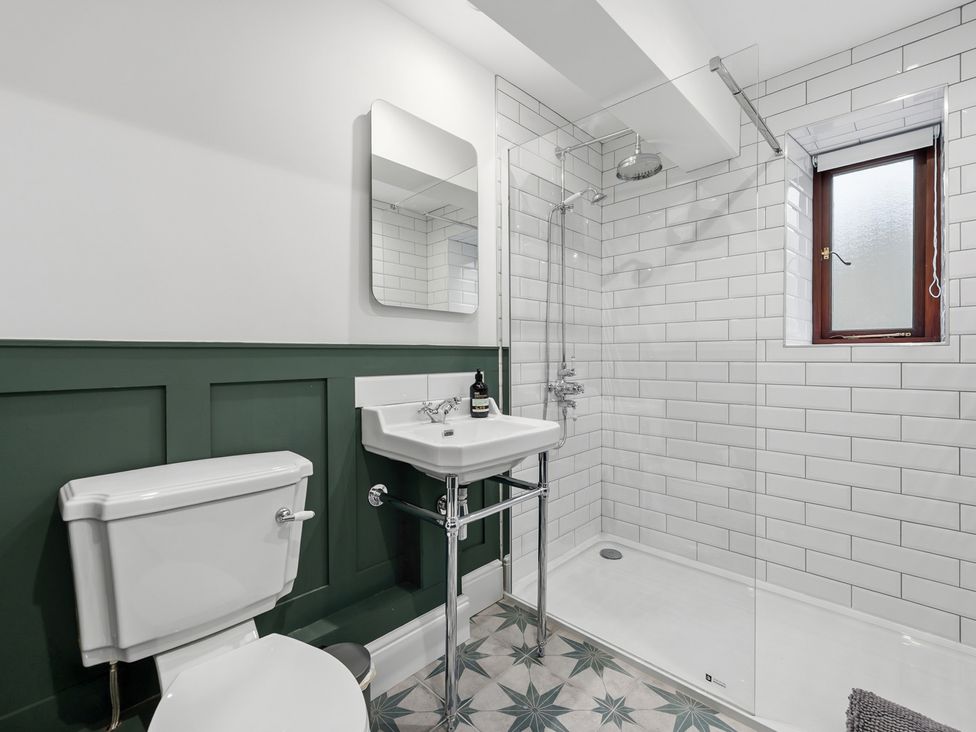 A bathroom with a toilet, sink, shower and window at The Forge in Castleton, Peak District