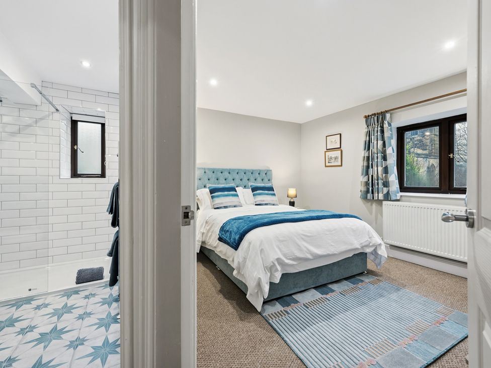 A bedroom with a bed and shower area at The Forge in Castleton, Peak District