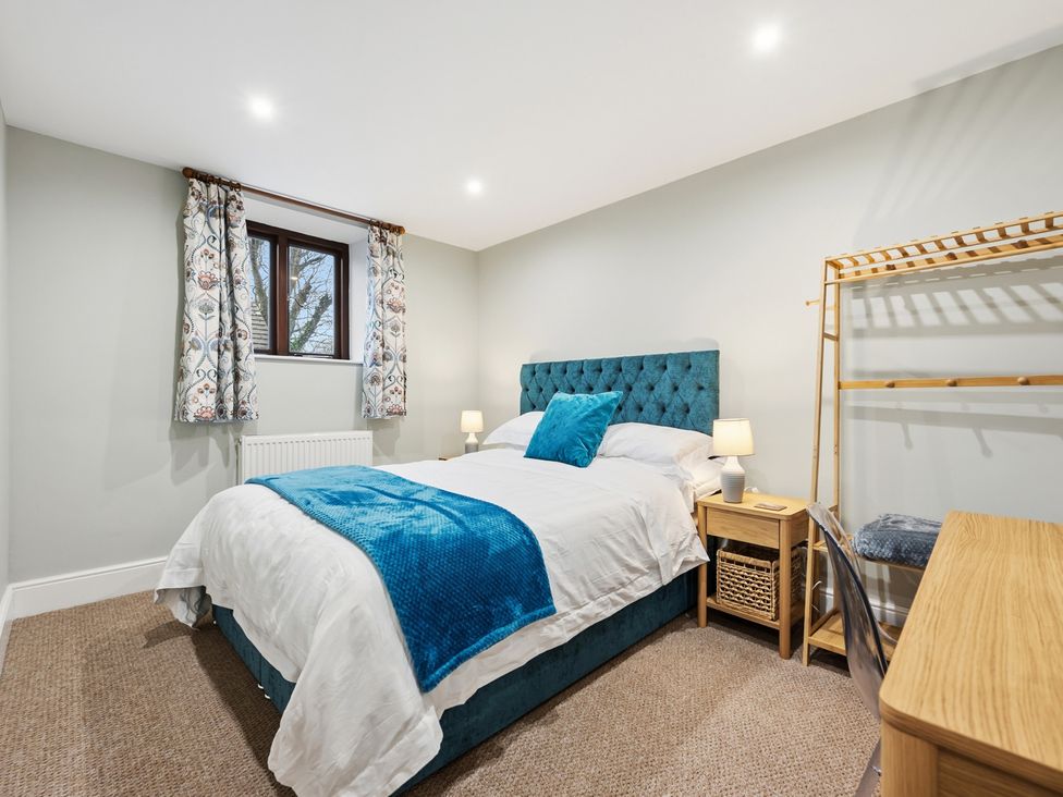 A bedroom with a bed and window at The Forge in Castleton, Peak District