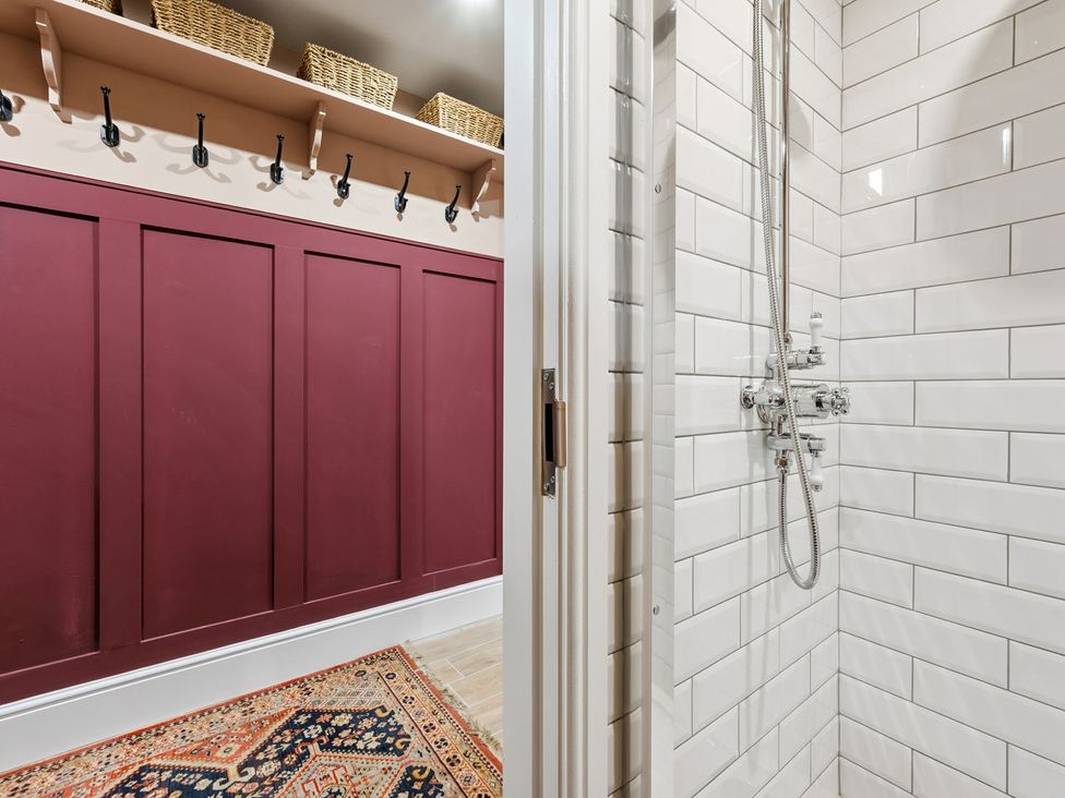 A bathroom featuring a shower with tile wall and storage rack at The Forge in Castleton, Peak District