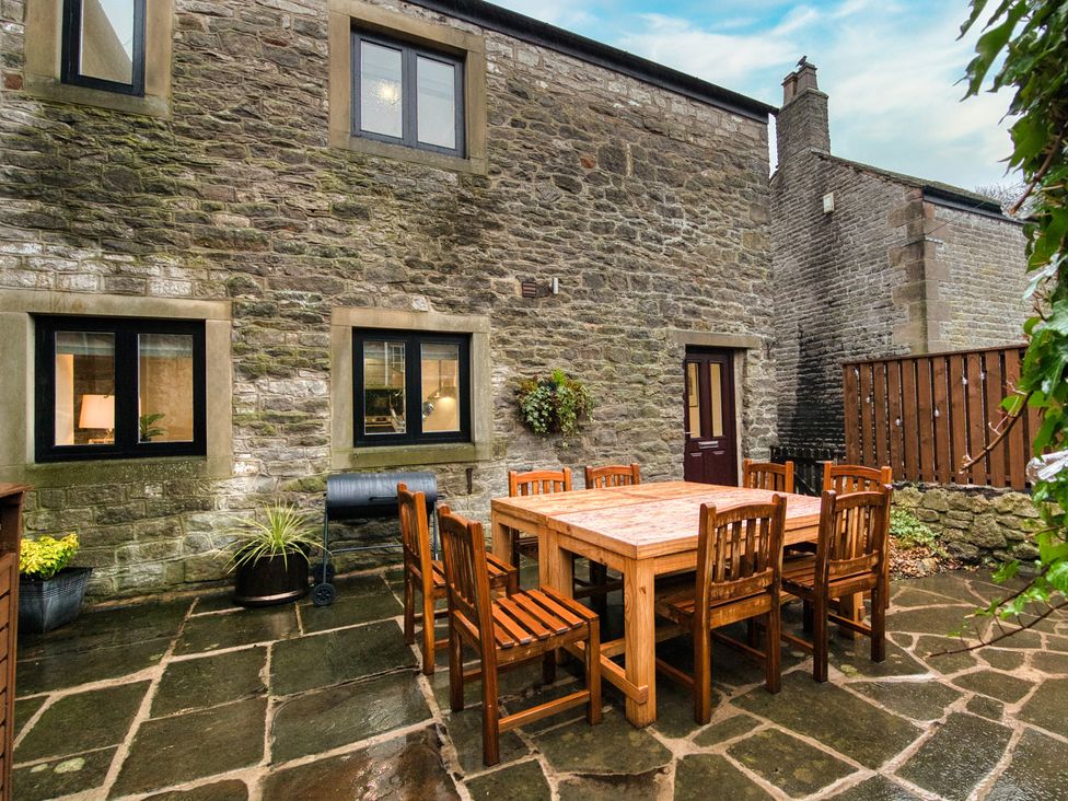 An outdoor dining area with a table and chairs at The Forge in Castleton, Peak District