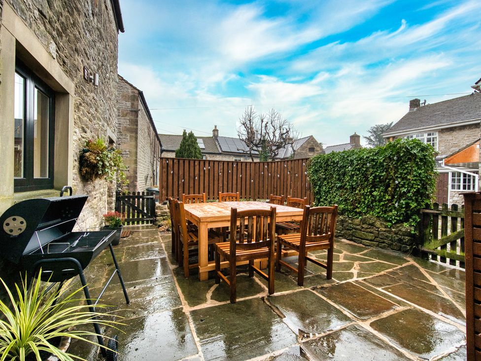 An outdoor dining area with a table and chairs at The Forge in Castleton, Peak District