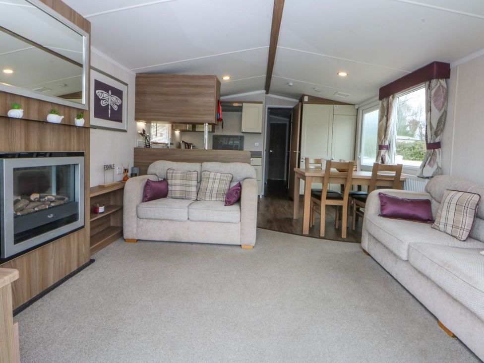 A living room with sofas and a dining table at 49 Cader Idris, Hafan-Y-Mor Holiday Park, Pwllheli