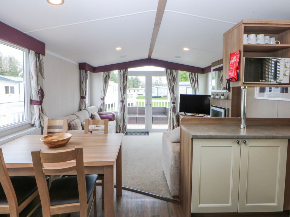 A living room with a dining area and sofa at 49 Cader Idris, Hafan-Y-Mor Holiday Park Pwllheli