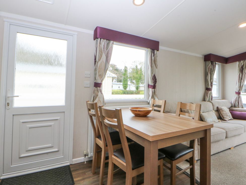 A dining area with a table and chairs at 49 Cader Idris, Hafan-Y-Mor Holiday Park Pwllheli