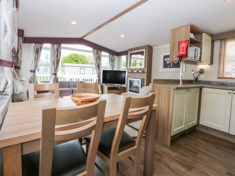 A dining room with a table and chairs at 49 Cader Idris, Hafan-Y-Mor Holiday Park Pwllheli