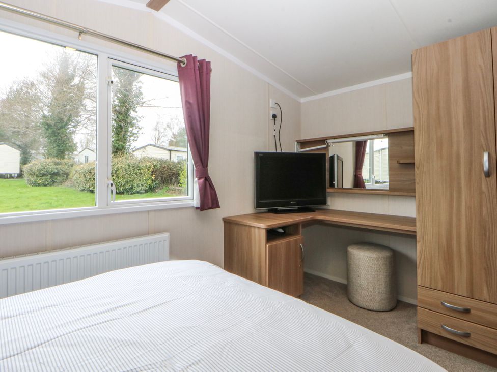 A bedroom with a desk and television at 49 Cader Idris, Hafan-Y-Mor Holiday Park Pwllheli