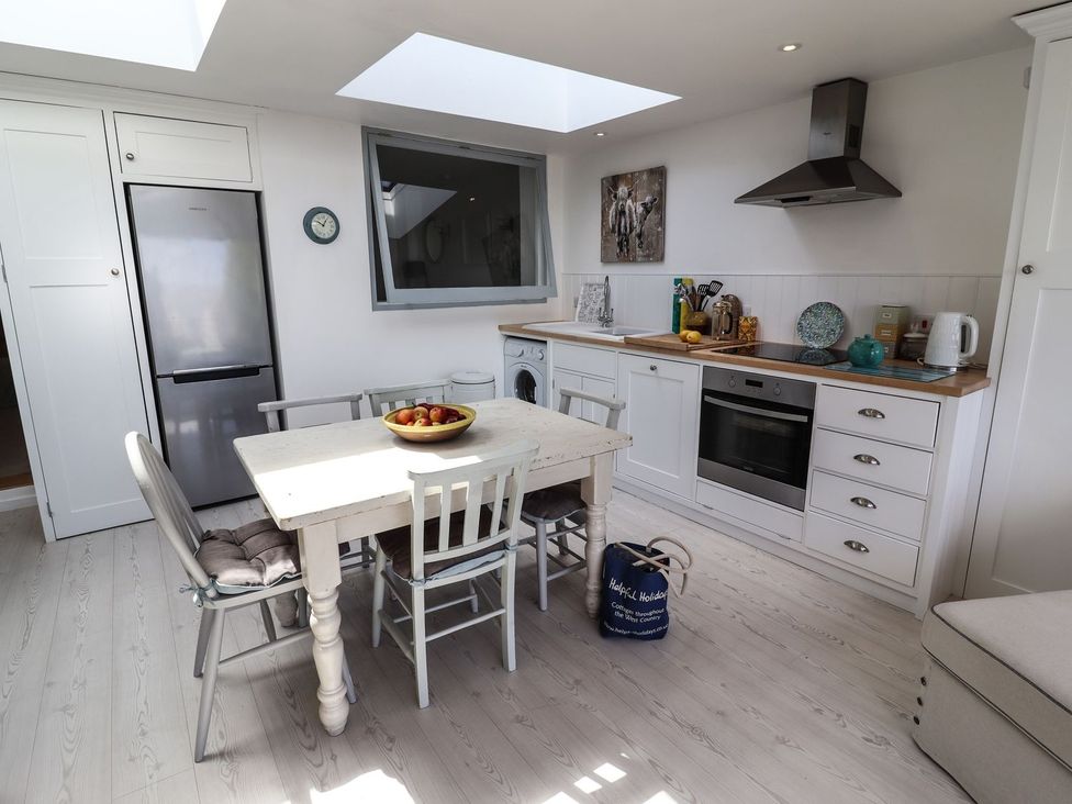 A kitchen with a table and chairs at Mariners Cottage in Bideford