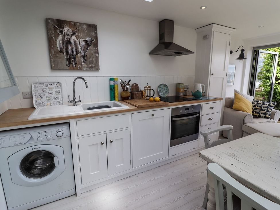 A kitchen with a washing machine and stove at Mariners Cottage in Bideford