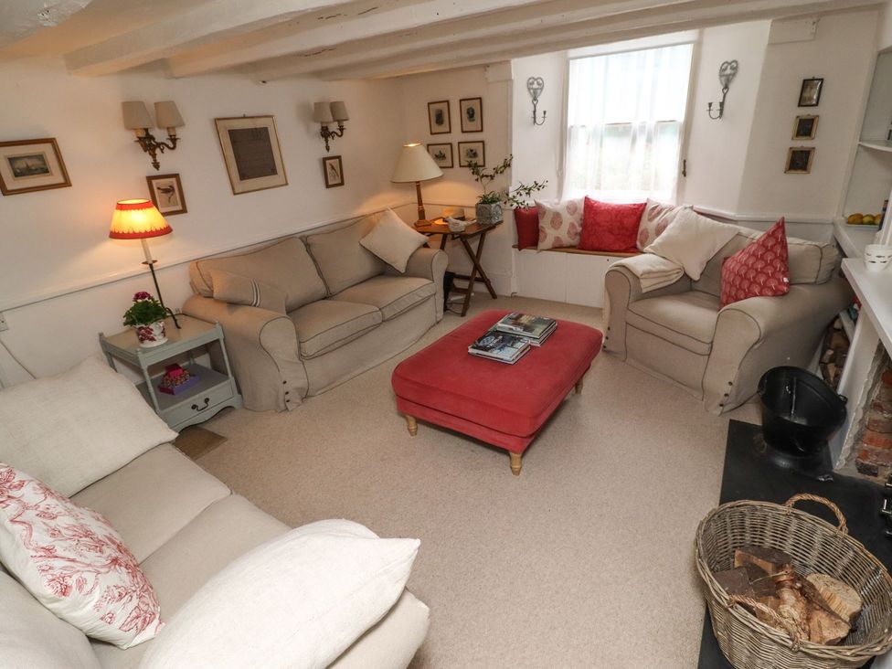 A living room with sofas and an ottoman at Mariners Cottage in Bideford