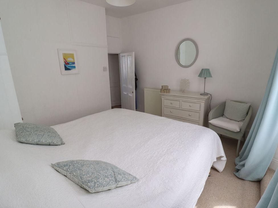 A bedroom with a bed and a dresser at Mariners Cottage in Bideford