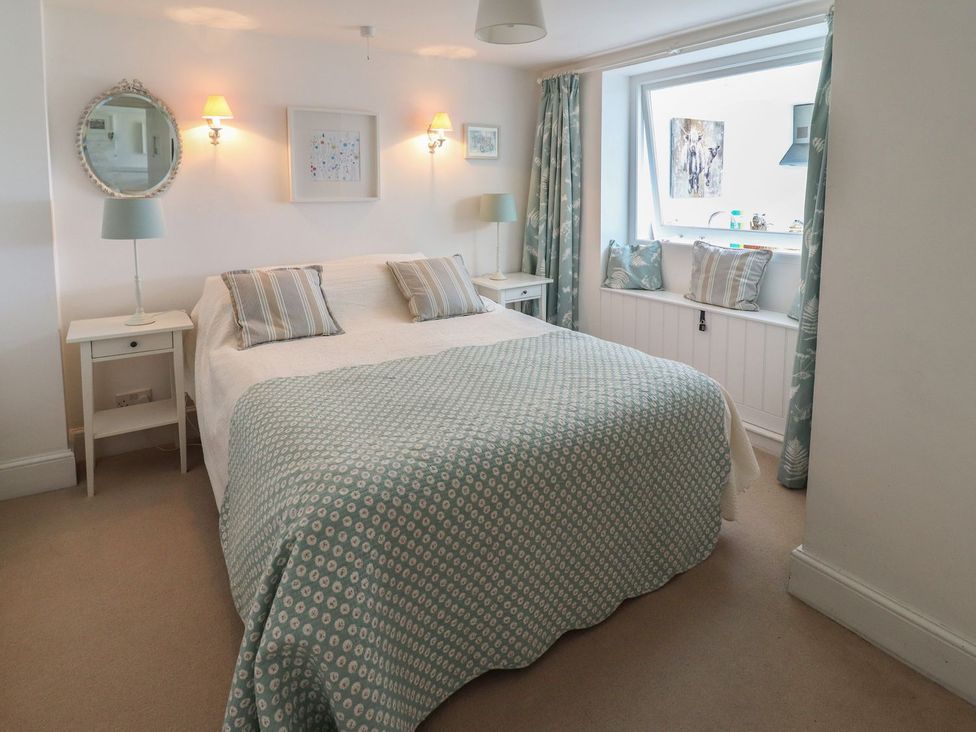 A bedroom with a bed and bedside table at Mariners Cottage in Bideford