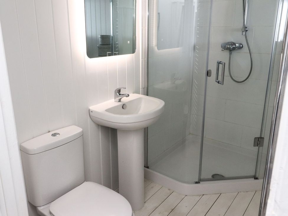 A bathroom with a sink, toilet, and shower at Mariners Cottage in Bideford