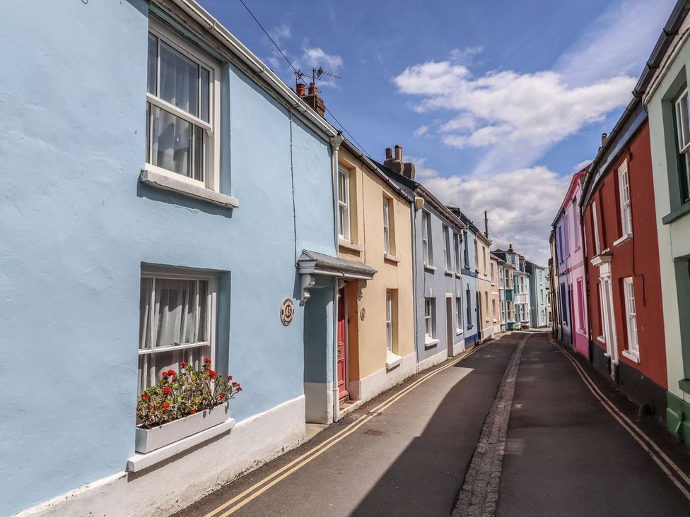 A street with colorful buildings and flower boxes at Mariners Cottage in Bideford