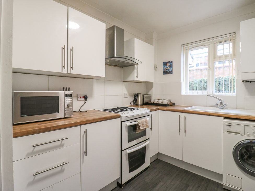 A kitchen with white cabinets and appliances at Wizard's Hideaway in Watford
