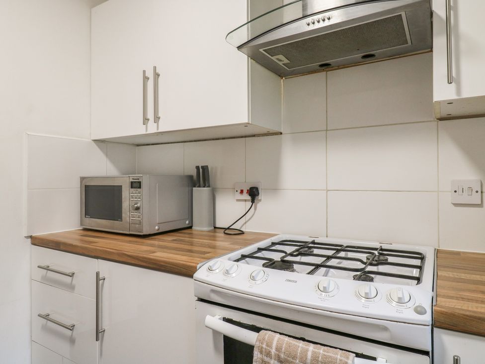 A kitchen with a microwave and gas stove at Wizard's Hideaway in Watford