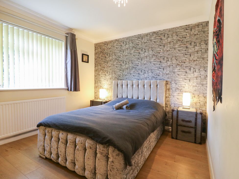 A bedroom with a bed and bedside tables at Wizard's Hideaway in Watford