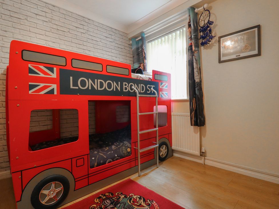 A bunk bed designed like a London bus in a bedroom at Wizard's Hideaway in Watford
