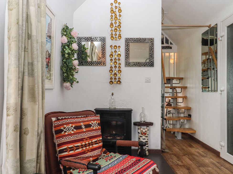 A living room with a chair and staircase at The Old Telephone Exchange in Exeter