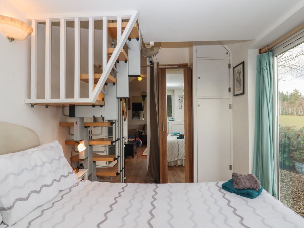 A bedroom with a bed and stairs at The Old Telephone Exchange Exeter
