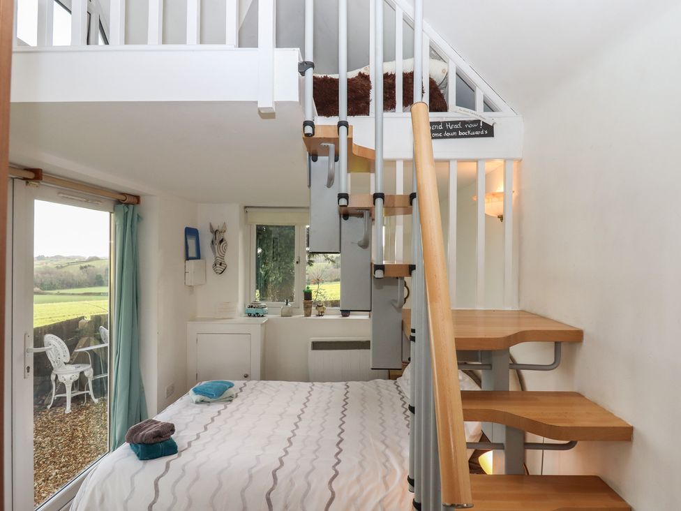 A bedroom with stairs and windows at The Old Telephone Exchange in Exeter