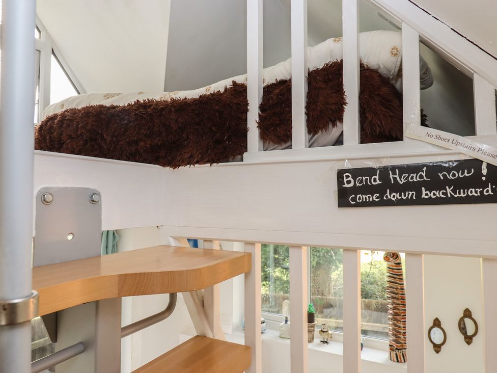 A loft bed with a pillow and a sign in a bedroom at The Old Telephone Exchange in Exeter