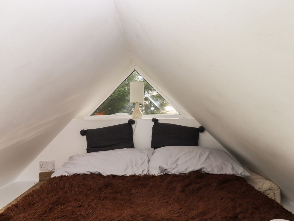 A bedroom with a bed, pillows and a lamp at The Old Telephone Exchange Exeter