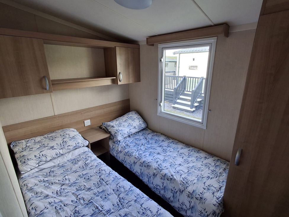 A bedroom with two beds and a window in Caravan