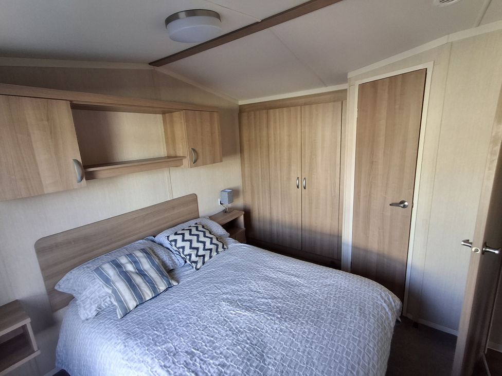 A bedroom with a bed and a bedside table at Caravan