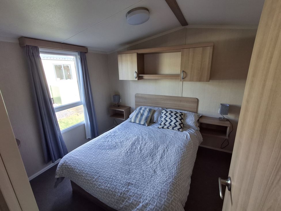 A bedroom with a bed and bedside tables at Caravan 
