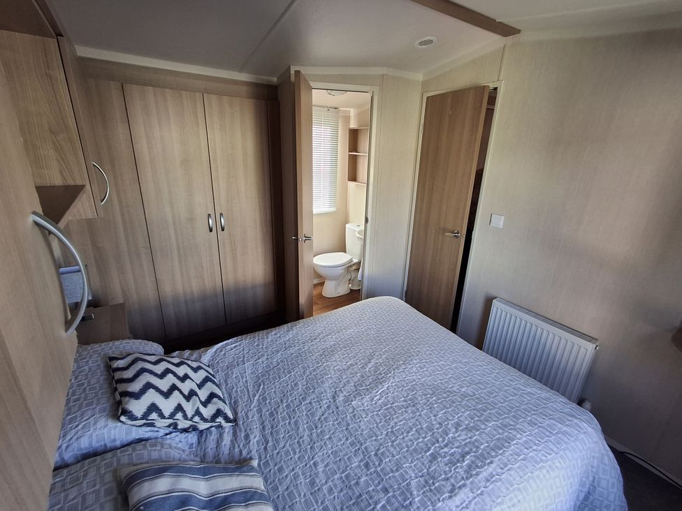 A bedroom with a bed and adjoining bathroom at Caravan