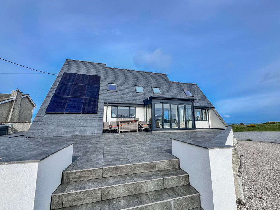 A house with solar panels and outdoor seating at Pengarnedd in Amlwch