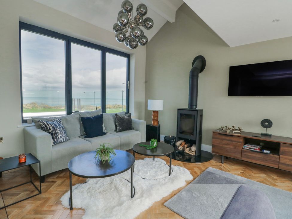 A living room with a sofa and a television at Pengarnedd in Amlwch