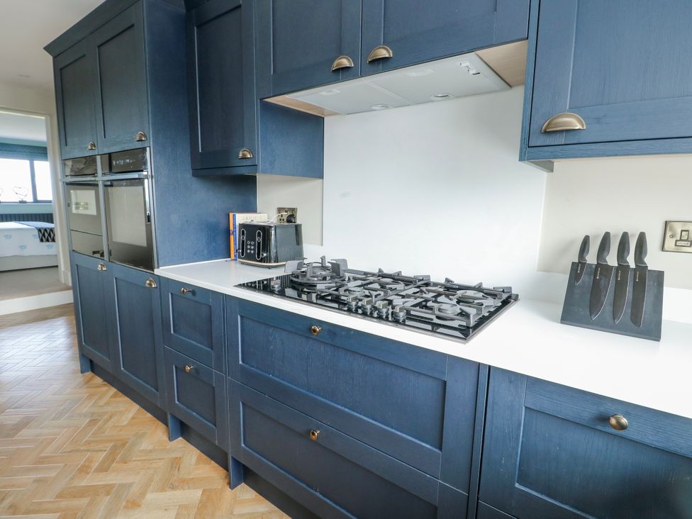 A kitchen with gas stove and appliances at Pengarnedd Amlwch