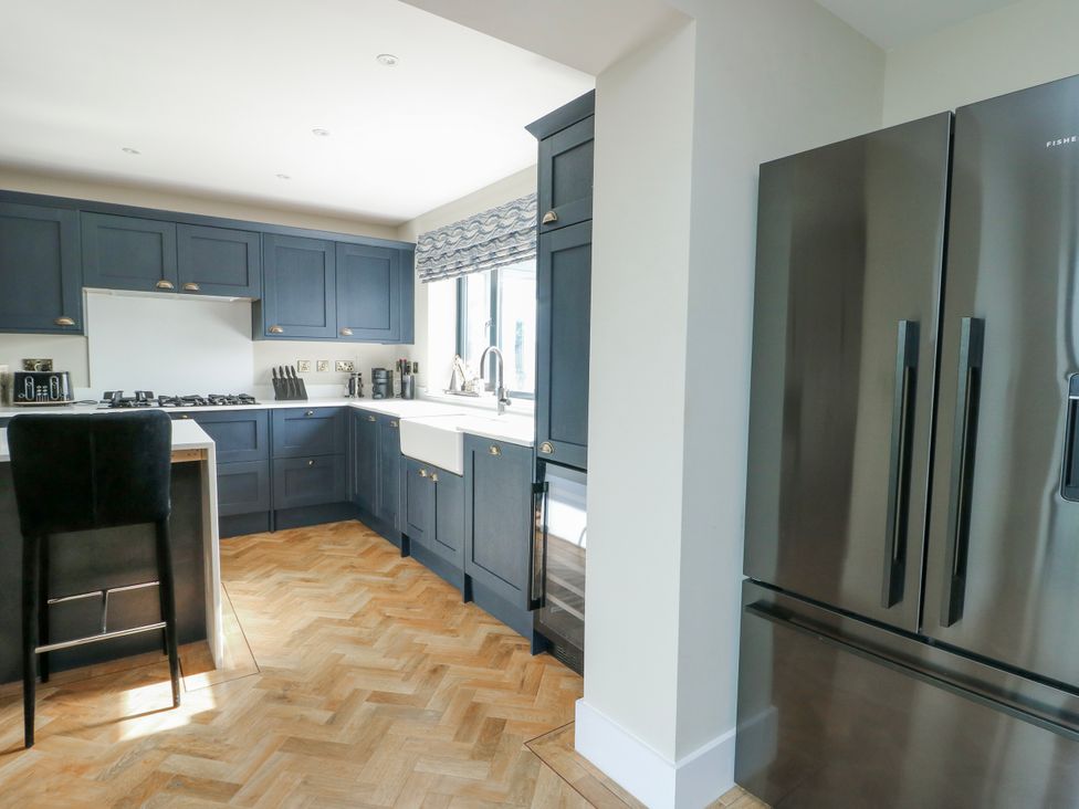 A kitchen with dark cabinets and stainless steel appliances at Pengarnedd in Amlwch
