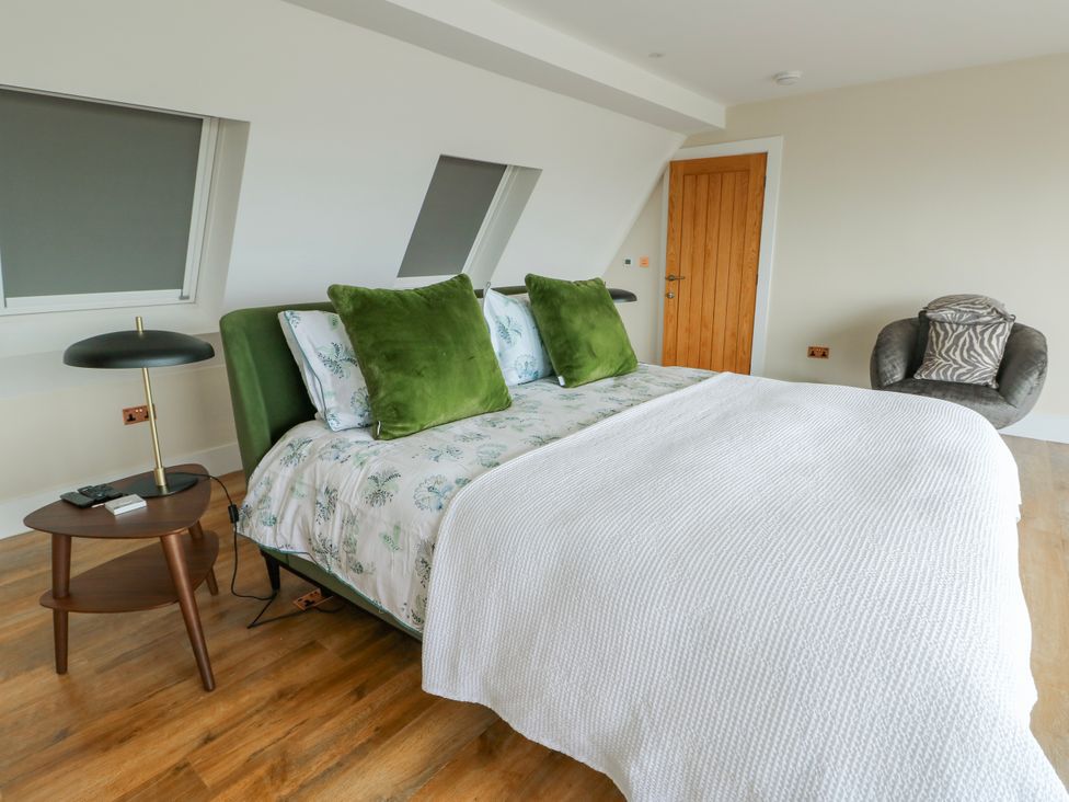 A bedroom with a bed and side table at Pengarnedd in Amlwch