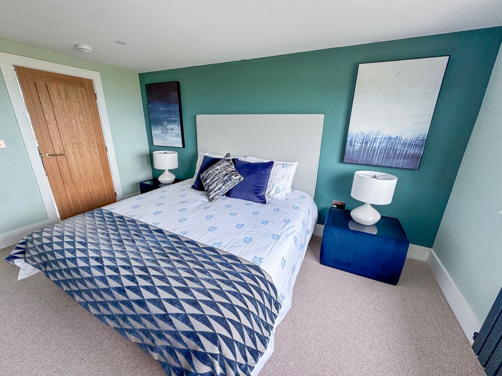 A bedroom with a bed and two bedside tables at Pengarnedd in Amlwch