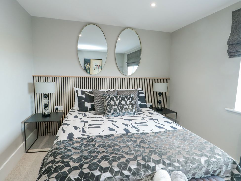 A bedroom with a bed and mirrors at Pengarnedd in Amlwch