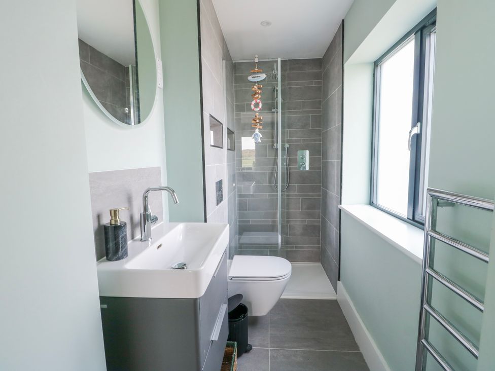 A bathroom featuring a sink, shower, and toilet at Pengarnedd in Amlwch