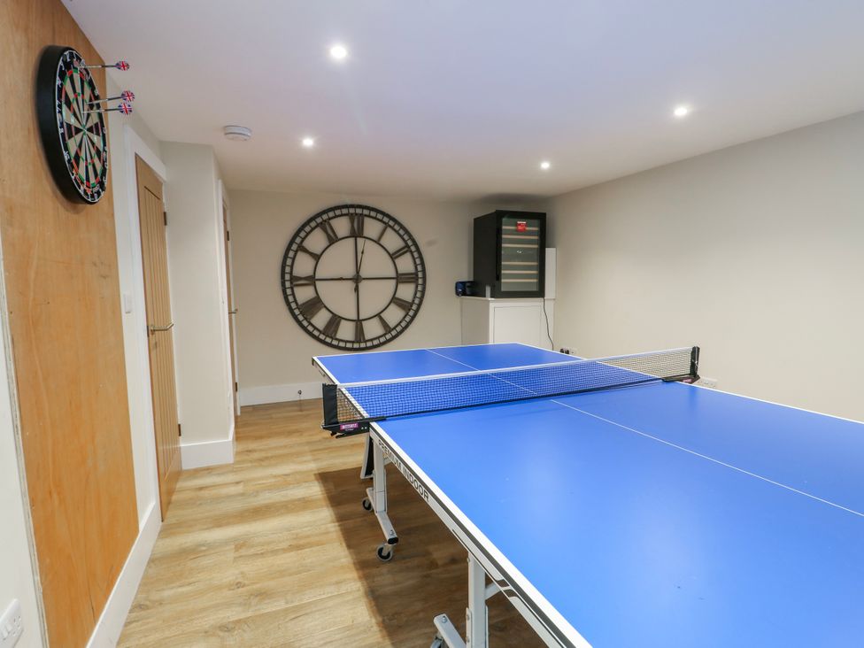 A game room with a table tennis table and dartboard at Pengarnedd in Amlwch