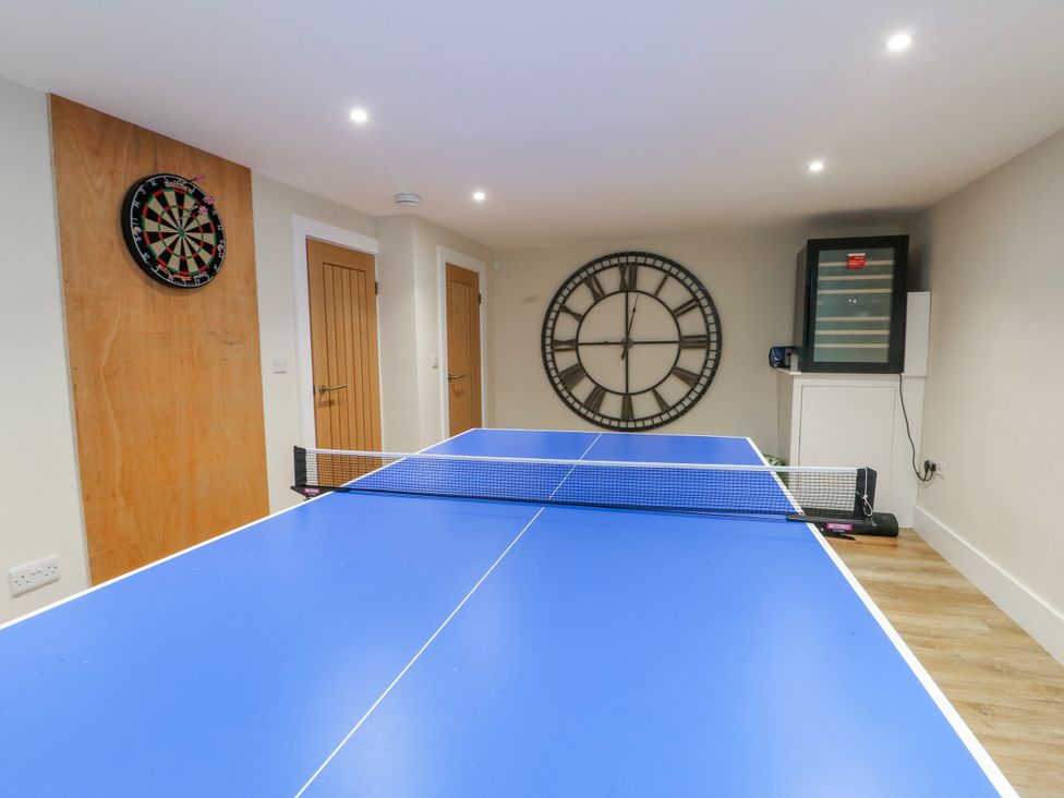 A game room with a table tennis table and dartboard at Pengarnedd in Amlwch