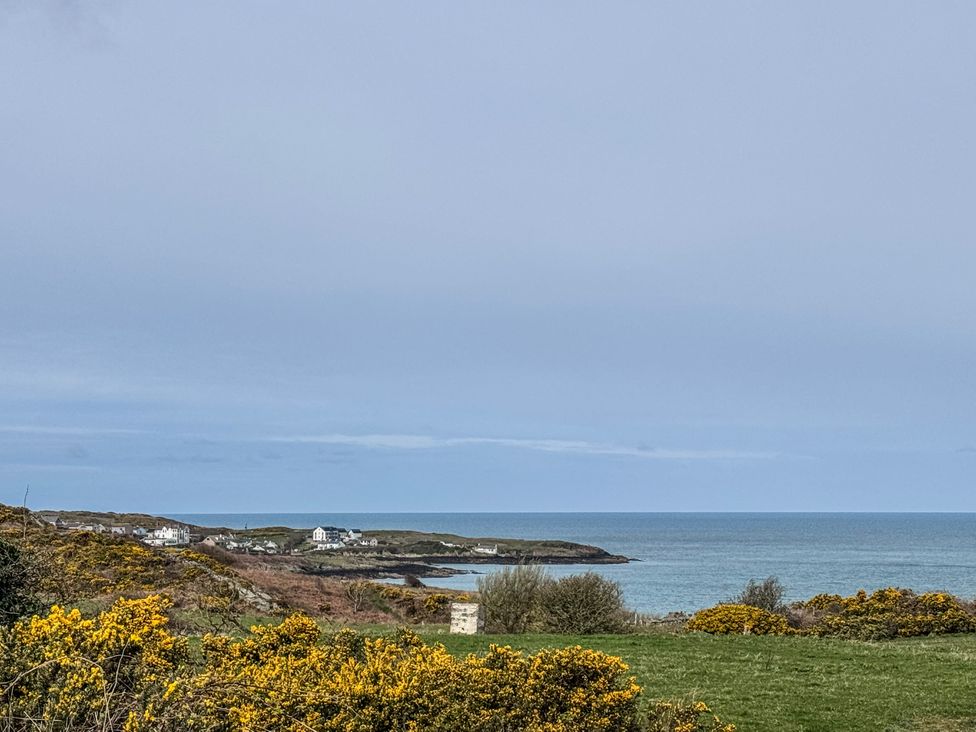 A view of the sea and houses along the coast at Pengarnedd in Amlwch