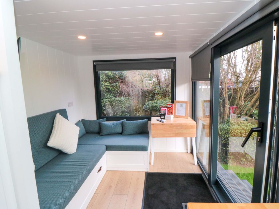 A living room with a sofa and table at The Tiny Home