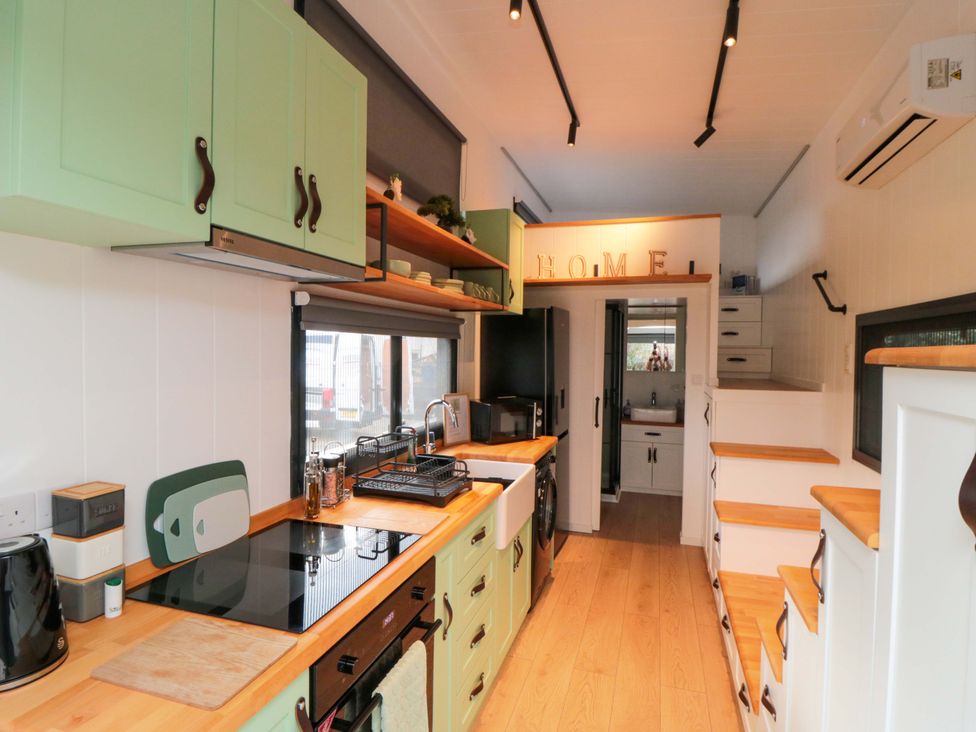 A kitchen with green cabinets and kitchen appliances at The Tiny Home