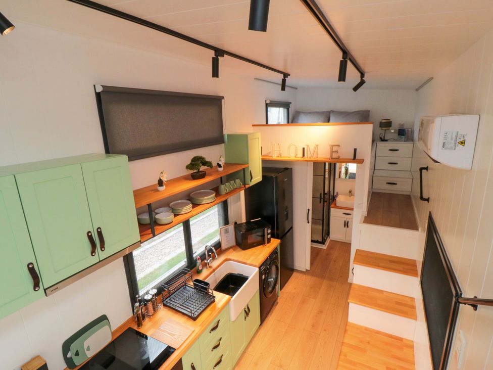 A kitchen with cabinets and a refrigerator at The Tiny Home